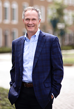 Bill Ebbing, President and CEO of The New Albany Company, standing outdoors.